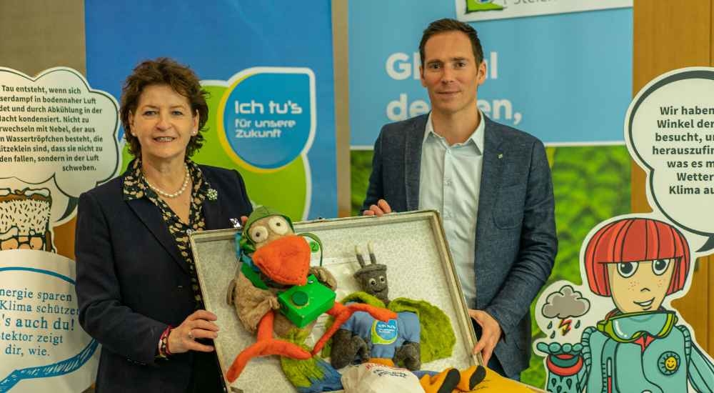 Landesrätin Ursula Lackner mit Fritz Hofer hinter der Klimakiste mit der Klimachecker Spielfigur