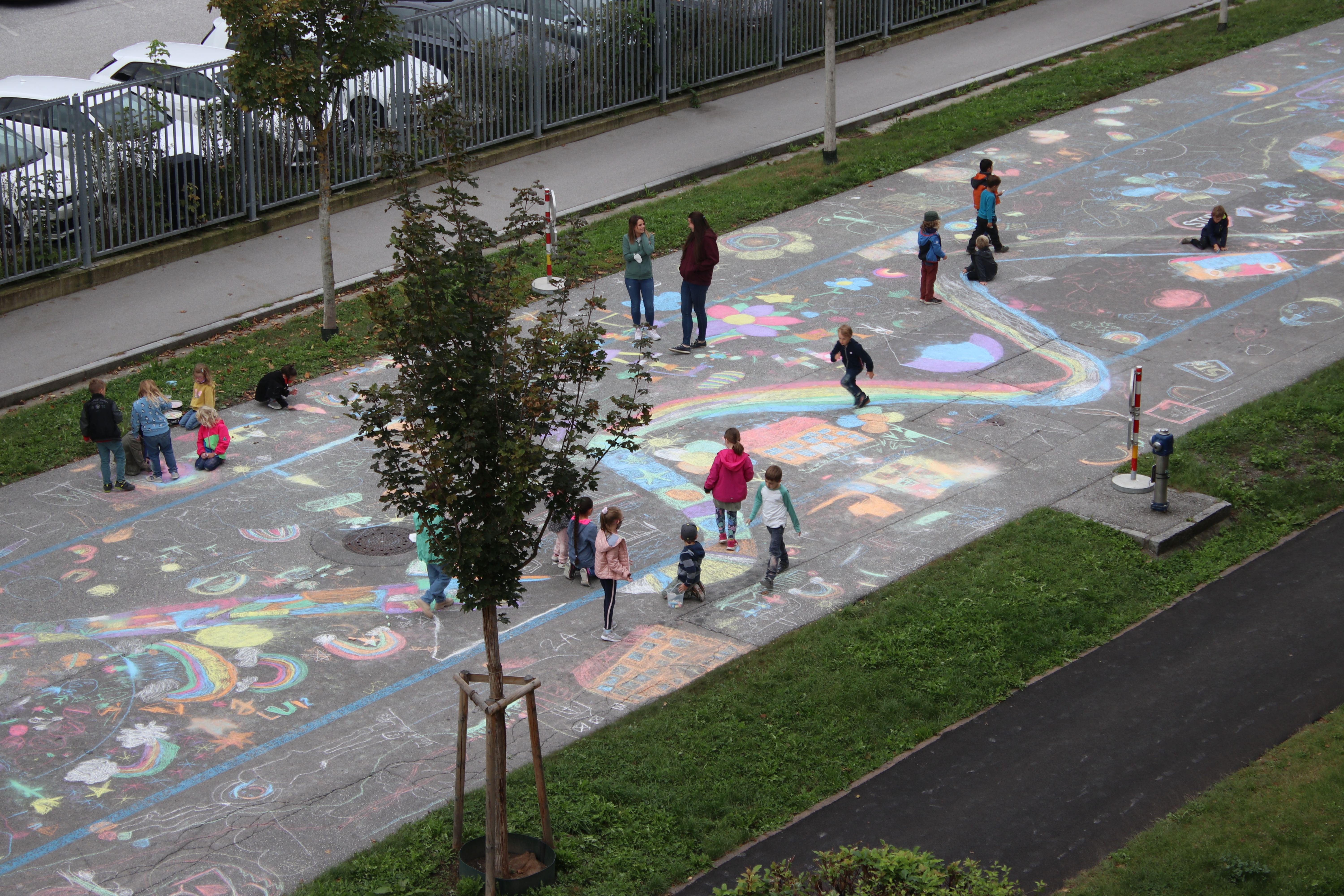 Kinder malen mit Kreide auf Straße Ansicht von oben