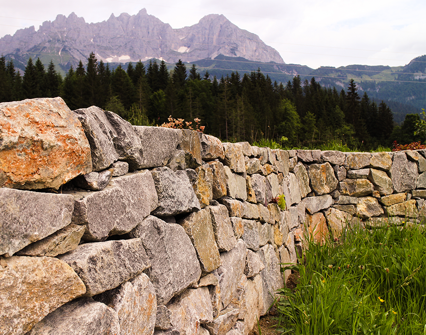 aufgeschichtete Trockensteinmauer vor Bergpanorama