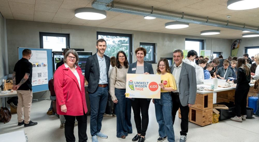Gruppenfoto bei den Umwelt Wissen Tage, die Kinder sind im Hintergrund beim Ausprobieren und Lernen