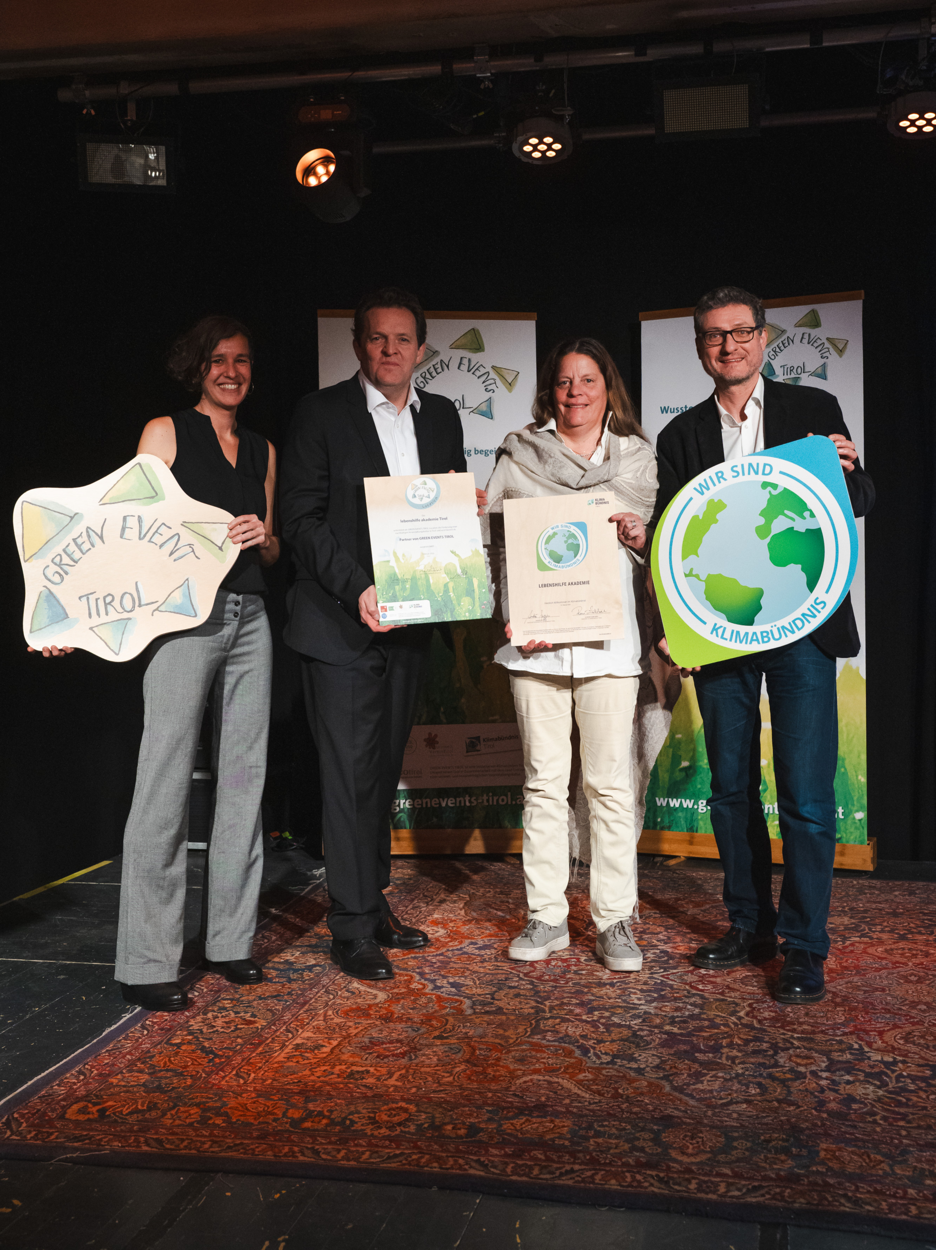 Gruppenfoto zwei Frauen und zwei Männer mit Klimabündnis Tafel, Green EventTirol Tafel und Urkunde