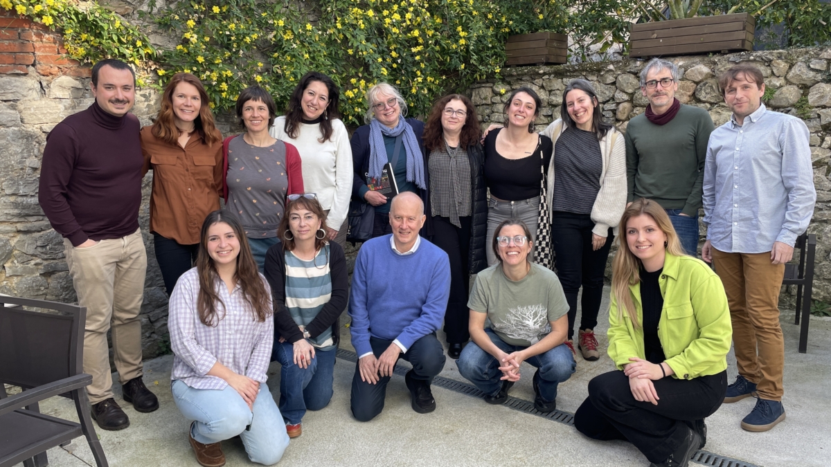 Gruppenfoto von ungefähr 15 Menschen die in die Kamera lächeln