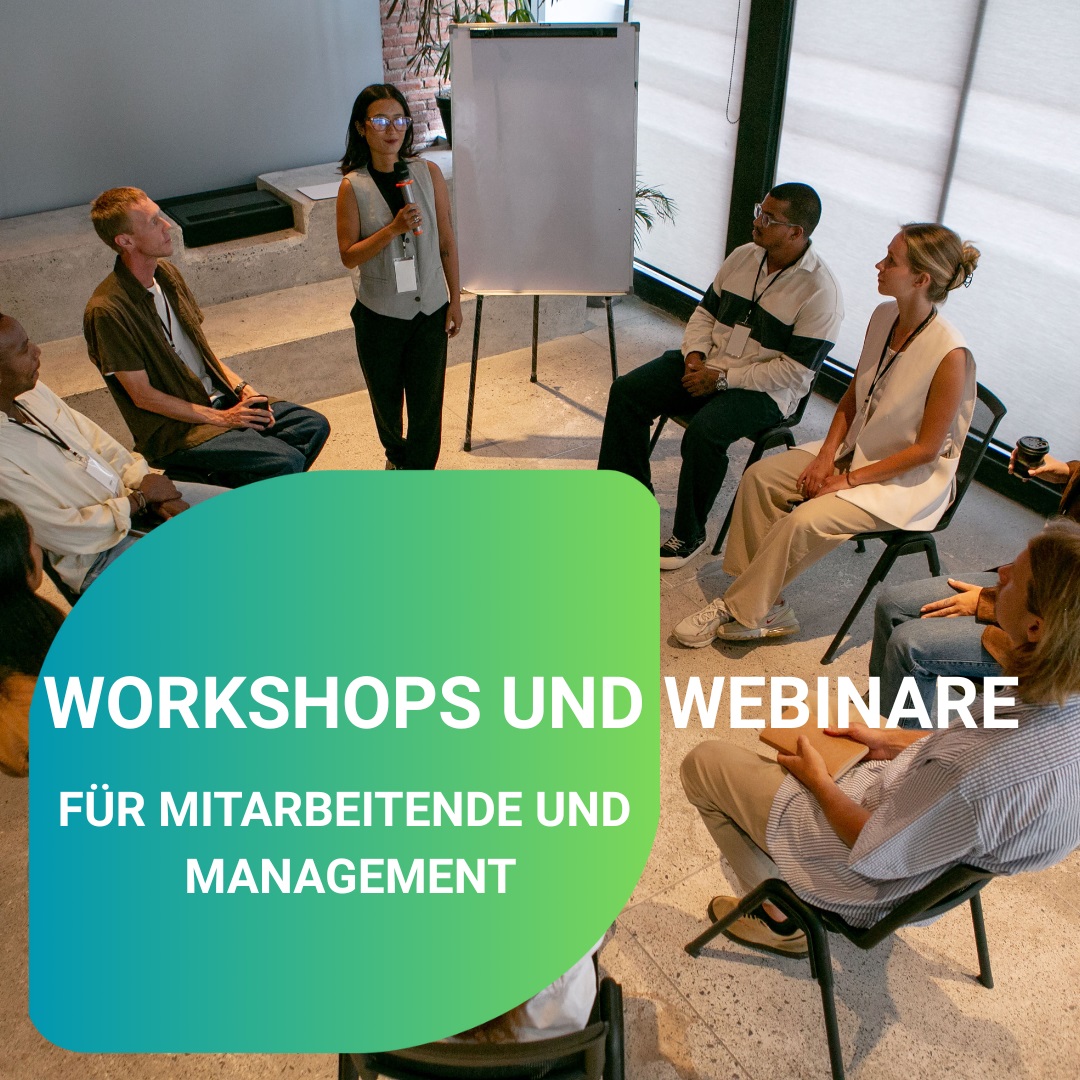 Gruppe von Menschen in einem Workshop, eine Person spricht vor einem Flipchart