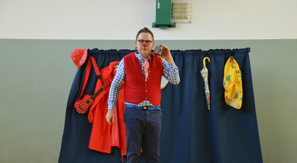 Klimaclown Dudu mit Radio auf Bühne