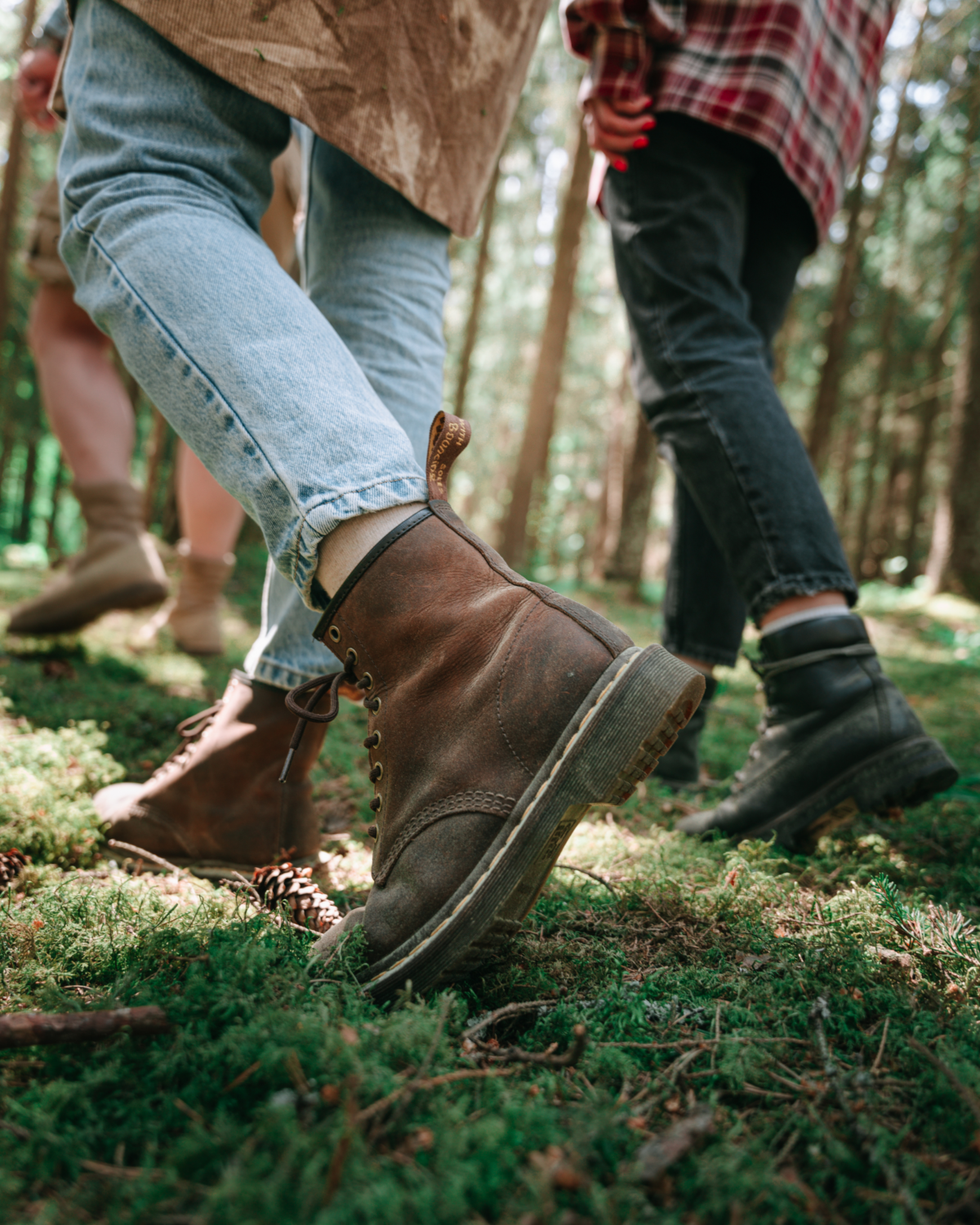 Menschen mit Wanderschuhen gehen durch einen Moosbedeckten Wald