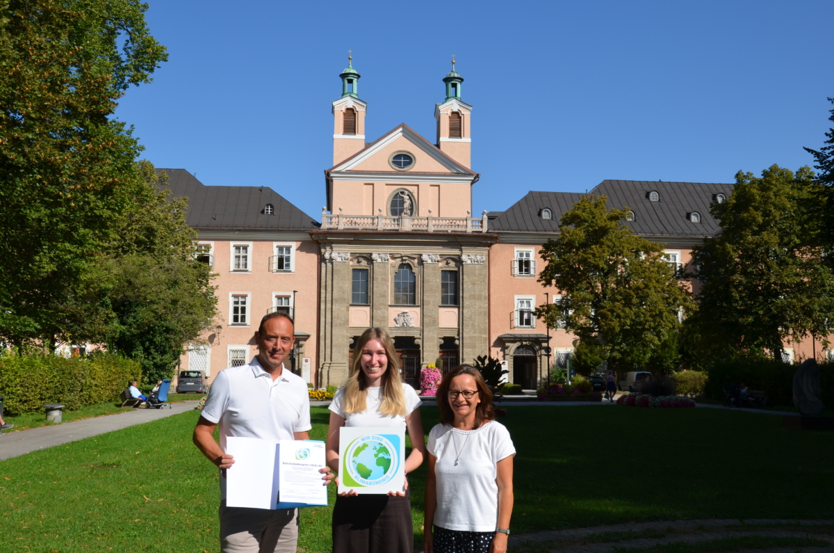 Drei Personen mit Urkunde